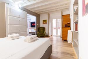 a bedroom with a white bed and a green chair at Elegantis Monti Suite Apartment in Rome