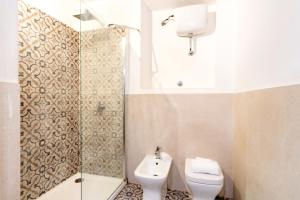 a bathroom with a shower and a toilet and a sink at Elegantis Monti Suite Apartment in Rome +32 photos