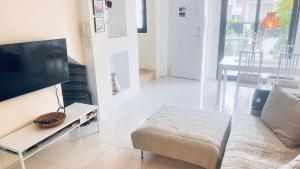 a living room with a couch and a flat screen tv at Duplex Zenia beach, La zenia in Playa Flamenca