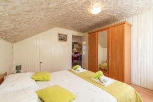 Un dormitorio con una gran cama blanca con almohadas amarillas. en Three Bedroom Holiday Home with Pool, en Molunat