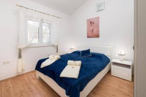 a bedroom with a blue bed and a window at Countryside Villa With Pool, Three Bedrooms in Vučevica +19 photos