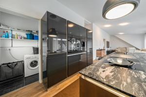 a kitchen with a sink and a washer and dryer at City Villa Bad Dürrheim - Penthouse in Bad Dürrheim
