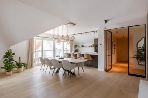 Un comedor con una mesa y sillas blancas. en Seaholiday Nieuwpoort met zicht op de jachthaven, en Nieuwpoort