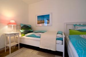 ein Schlafzimmer mit 2 Betten und einem Tisch mit einer Lampe in der Unterkunft Ostseesonne in Prerow