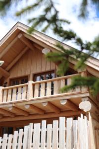a wooden balcony on a house with a fence at Bründl-Chalets Hochrindl in Sirnitz-Sonnseite +8 photos