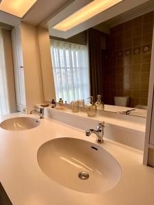 a bathroom with two sinks and a large mirror at 't Reigergoed in Ichtegem +19 photos
