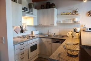 a kitchen with white cabinets and a counter top at Ferienwohnung Döbbelin in Prerow