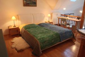 a bedroom with a large bed with a green blanket at Ferienwohnung Döbbelin in Prerow