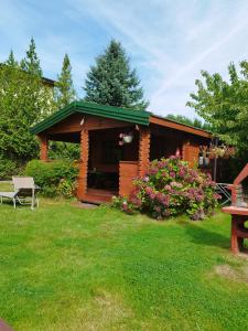 una cabaña con techo verde en un patio en Domki Szyper, en Władysławowo