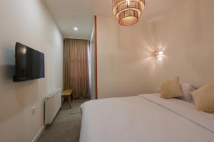 a hotel room with a bed and a television at Palm Tbilisi Boutique Hotel in Tbilisi City