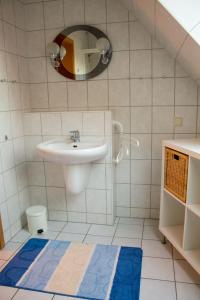 ein Bad mit einem Waschbecken und einem Spiegel in der Unterkunft Am Bernsteinweg in Prerow