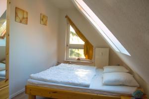 Bett in einem Zimmer mit Fenster in der Unterkunft Am Bernsteinweg in Prerow