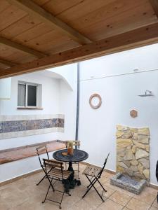 d'une terrasse avec une table, des chaises et une cheminée en pierre. dans l'établissement Alojamiento Rural Los Corrales, à Algodonales