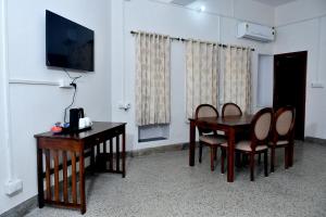 a room with a table and chairs and a television at Ranthambhore Tiger Territory in Sawāi Mādhopur