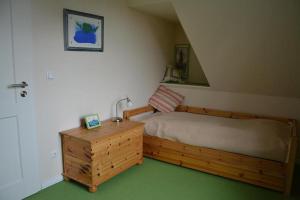 a bedroom with a bed and a dresser with a sink at Hagens Hus in Prerow