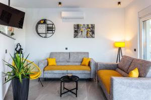 a living room with two couches and a table at Villa Vilma-house with heated pool & garden in Trilj