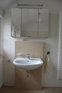uma casa de banho com um lavatório branco e um espelho. em Hagens Hus em Prerow
