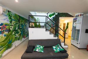 een woonkamer met een trap en een muurschildering bij Ohana Apart Hotel in Termas de Río Hondo