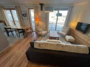 ein Wohnzimmer mit Sofa und Tisch in der Unterkunft Chalet de l'Olympe in Les Allues