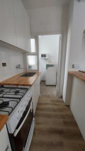 a kitchen with a stove and a sink at Departamento bolivar in Mar del Plata +3 photos