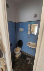 a blue tiled bathroom with a toilet and a sink at Departamento bolivar in Mar del Plata