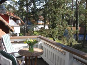 a table on a balcony with a vase of flowers at Strandlust in Prerow