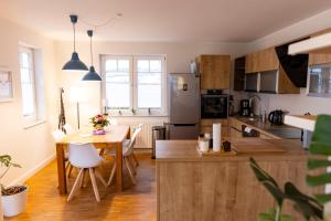 a kitchen with a wooden table and a dining room at SmartFewo - Home - Zentral - Terrasse - Parkplatz in Oldenburg