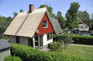 ein rotes und weißes Haus mit einem Dach in der Unterkunft Schäfer-Ast-Weg 21 in Prerow