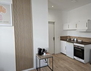 a kitchen with white cabinets and a table in it at Petite maison, Oyonnax centre in Oyonnax