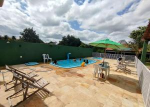 a swimming pool with people in it with an umbrella at Marcone Lima anexo in Barreirinhas +25 photos