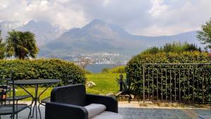 a patio with a table and chairs and a view of mountains at Villa Oliveto apartments in Oliveto Lario