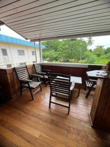 a group of chairs and tables on a patio at Qua Roviana Accommodation in Munda