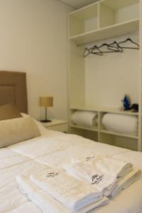 a bed with two white towels on top of it at Don Pedro Apart Hotel in Corrientes