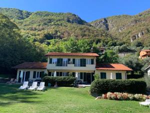 a house with chairs and mountains in the background at Villa Oliveto apartments in Oliveto Lario