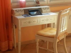 a white desk with a chair next to a window at Am Stemsbach in Prerow