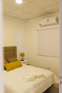 a bedroom with a white bed with a yellow pillow at Don Pedro Apart Hotel in Corrientes +20 photos