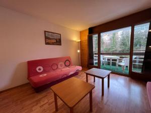 a living room with a red couch and a table at Appartement pour 4 avec parking in Vionnaz