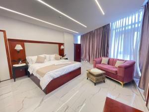 杰拉什Jerash Hotel的配有床和沙发的酒店房间