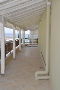 una passerella con colonne bianche e l'oceano sullo sfondo di Villa Nikolas a Paralia Katerinis