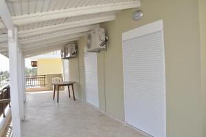 una porta bianca in garage in una stanza con tavolo e sgabello di Villa Nikolas a Paralia Katerinis