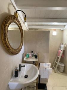 Un baño con un lavabo y un espejo en la pared. en BADIA SAN MICHELE Pajara Aida, en Tuglie