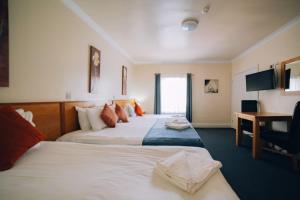 a hotel room with two beds and a desk at Rooms At 95 Long Street in Atherstone
