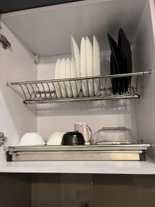 a shelf in a kitchen with plates and utensils at Sukoon by Urban Retreat in New Delhi