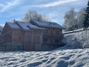 ein großes Holzhaus im Schnee mit Schnee in der Unterkunft Chalet de l'Olympe in Les Allues