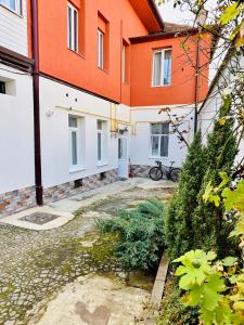an orange and white building with a bike in the courtyard at Green House Studios in Braşov