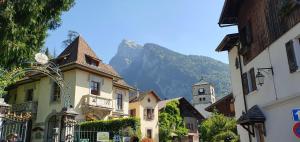 una strada con edifici e una montagna sullo sfondo di Les Couadzous Samoëns Centre, Sauna, Jacuzzi, 6 chambres, 7 salles de bains, 16 pers 250 m2 a Samoëns