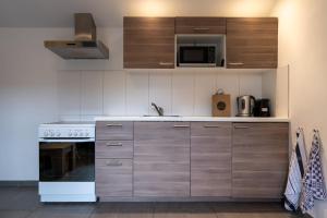 a kitchen with a stove and a microwave at Hello Zeeland - Vakantiehuis Wijngaardstraat 12A in Domburg