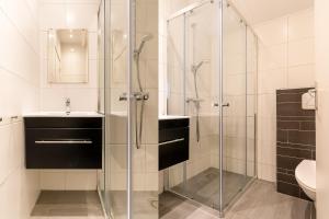 a bathroom with a glass shower and a sink at Hello Zeeland - Vakantiehuis Wijngaardstraat 12A in Domburg