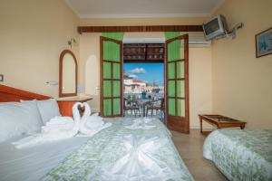 a hotel room with a bed and a balcony at Anadiomeni Pool & Beach Apartments by "elite" in Zakynthos +40 photos