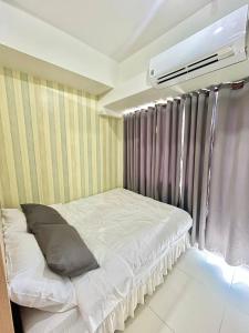 a bedroom with a bed and a air conditioner at The Luna's at Wind Residences in Kaybagal
